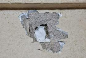 The couple claim the persistent knocking has left a large hole in the living room wall.
