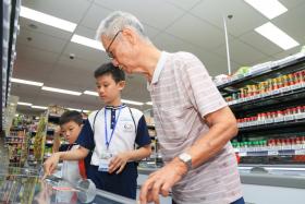 Jannik Oh and Jerick Oh helping Mr Guo Zanxiang shop for groceries.