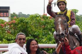 Bruno Queiroz saluting aboard his May 4 winner Free And Happy with his proud parents Antonio, also a jockey, and Sandra by his side.
