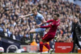 Kevin De Bruyne (left) of Manchester City in action against Andrew Robertson (R) of Liverpool on April 10, 2022. 