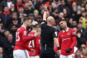 Manchester United's Brazilian midfielder Casemiro (right) is shown a red card by English referee Anthony Taylor.