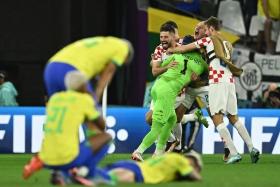 Croatia&#039;s Dominik Livakovic celebrating with teammates after winning the penalty shootout 4-2 against Brazil to progress to the World Cup semi-finals.