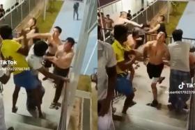 In videos shared on social media, migrant workers can be seen fighting one another at a stairwell in a dormitory.
