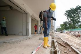 Larvicide being sprayed into drains at a construction site to prevent dengue mosquitos from breeding, on June 3, 2022.