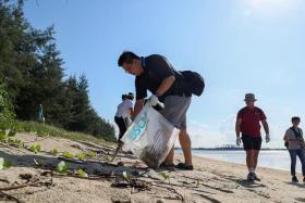 People helping to pick up marine litter at Tanah Merah beach on June 5, 2022.