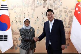 President Halimah Yacob (left) and South Korea's President Yoon Suk-yeol meet after his inauguration ceremony in Seoul on May 10, 2022.