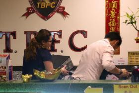 Officers from the Commercial Affairs Department removing cartons of documents from the Football Association of Singapore office during a raid on 20 April 2017 as part of a probe into the alleged misuse of funds at Tiong Bahru Football Club. 