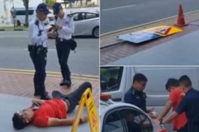 In a video shared on social media, the driver is seen lying on a pedestrian walkway while a road sign lies on the ground.
