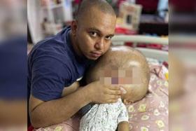 Mr Mohammad Azhar Arzemi holding his child, who died from a birth defect on Dec 15.