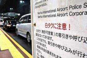 A sign warning against the use of unlicensed taxi services is seen at Narita Airport.