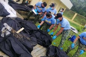 Police officers identify bodies of landslide victims in the Philippines&#039; Baybay City on April 12, 2022.