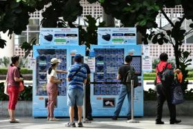 People collecting masks at vending machines outside Bedok Mall on March 3, 2021.