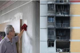 Mr Samuel Seah cleaning a wall in his flat, which is covered in soot after a blaze in the unit two floors below.