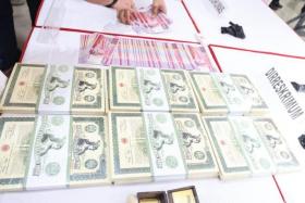 Counterfeit $10,000 notes confiscated by Indonesia, alongside old bearer bonds that were discovered.