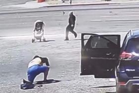 In surveillance video, a person is seen loading up a parked car when a stroller with a baby starts rolling towards a busy road. 