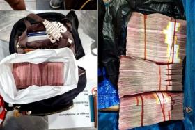 The cash was wrapped in plastic bags and divided into three stacks that were placed into two suitcases and a backpack, said the Immigration and Checkpoints Authority in a Facebook post on Monday. 