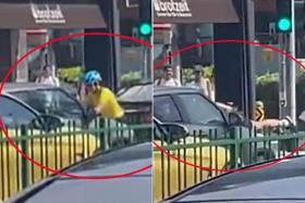Footage on social media showed a grey car driving off with a female cyclist clinging onto it after the cyclist obstructed the driver's path.