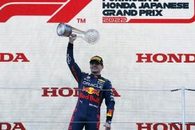 Max Verstappen celebrates winning the race and the championship on the podium at the Suzuka circuit in Japan on Oct 9, 2022.