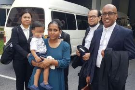 R. Devaki, who can be seen carrying her son, with her lawyers (from right) Haresh Mahadevan and Ramzani Idris outside the court.