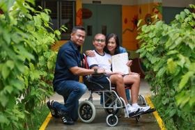 Gongshang Primary School pupil Izzat Hakim Sharif, who was diagnosed with metastatic medullablastoma, with his father Sharif Shariman and mother Raihana Mohd Nor, after receiving his PSLE results on Nov 23, 2022.