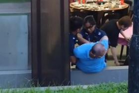 A TikTok video shows two police officers trying to restrain a man in a blue shirt who seems to be resisting getting handcuffed.