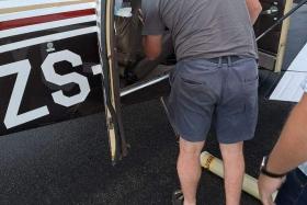 A snake catcher looking for the Cape cobra in the Beechcraft Baron 58 aircraft.