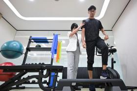 Mr Lionel Toh doing step ups using the stepboard during physiotherapy with Ms Lori Pang, 39, Principal Physiotherapist at Parkway Rehab.