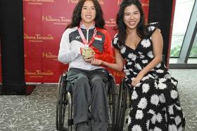 Yip Pin Xiu posing with Madame Tussaud's waxwork of her after the unveiling of the 2025 World Para Swimming Championships host city.